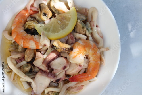 A seafood cocktail with shrimp, mussels and squid on a lemon plate is beautifully served for lunch.