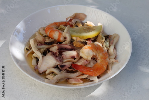 A seafood cocktail with shrimp, mussels and squid on a lemon plate is beautifully served for lunch.