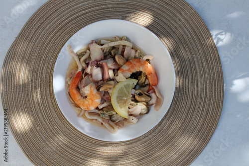 A seafood cocktail with shrimp, mussels and squid on a lemon plate is beautifully served for lunch.