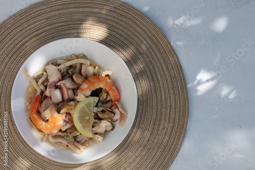 A seafood cocktail with shrimp, mussels and squid on a lemon plate is beautifully served for lunch.