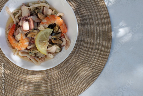 A seafood cocktail with shrimp, mussels and squid on a lemon plate is beautifully served for lunch.