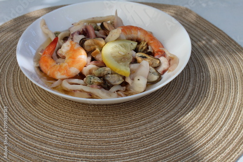 A seafood cocktail with shrimp, mussels and squid on a lemon plate is beautifully served for lunch.