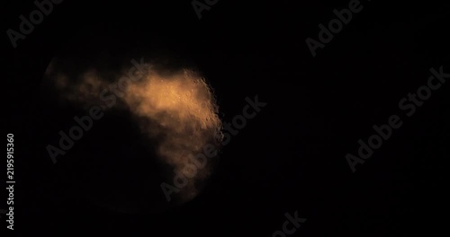 moon behind dark clouds in the night