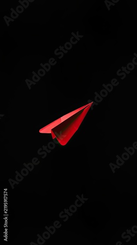 A red paper plane is flying through a dark background. The scene captures the concept of movement and creativity. It focuses on the shape and color