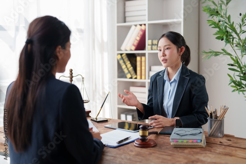 Female lawyer discussing legal advice with client in modern law firm office, offering professional legal consultation and justice services