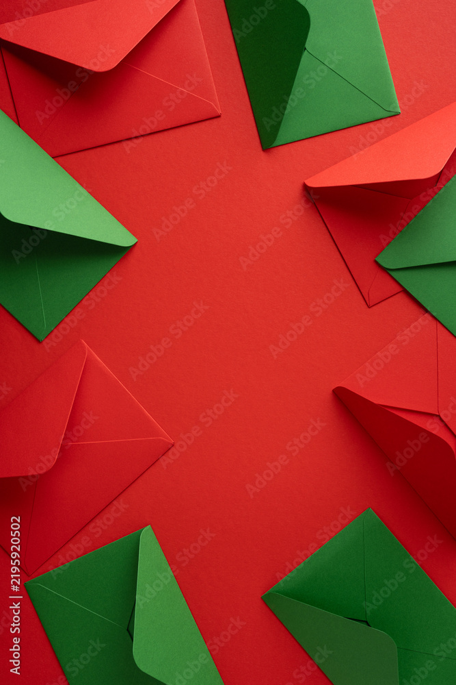 Obraz premium Christmas envelopes and letters to Santa with wishlist notes on red vertical background with empty space