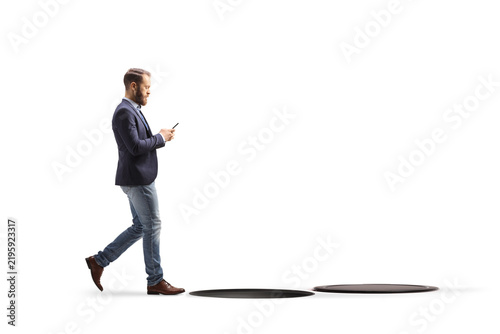 Man walking and typing at his phone about to fall into a hole