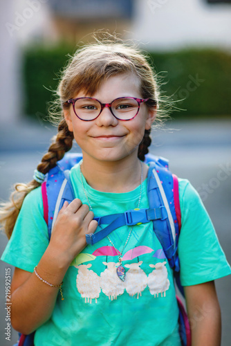Little Girl on the way to school with a backpack. Happy schoolgirl, back to school concept, walking outdoors with confidence and ready for a new school day