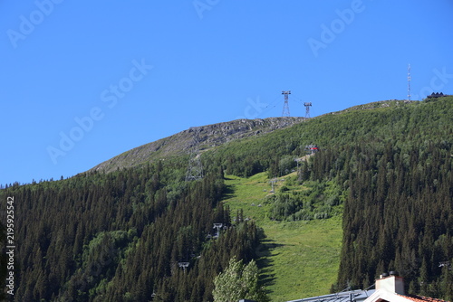 Åreskutan mountain with ski lifts and summit buildings under clear summer skies in Åre, Sweden.