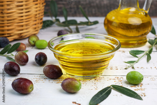 fresh olives and olive oil on wooden background