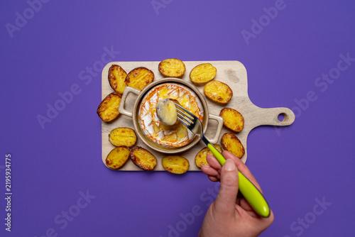 Obraz na plátne Fork lifting stretchy melted cheese from a baked camembert