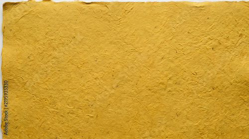 Close up of a smooth golden yellow textured surface background.