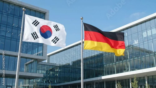 South korea and germany flags waving together in front of modern glass corporate office building international