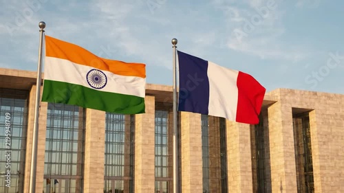 India and france flags waving together in front of modern government building international diplomacy and partnership concept