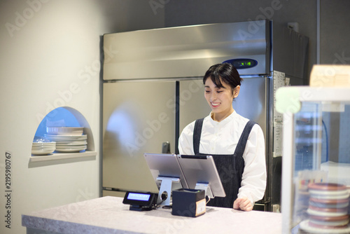 カフェでキャッシュレス決済を行う女性スタッフ