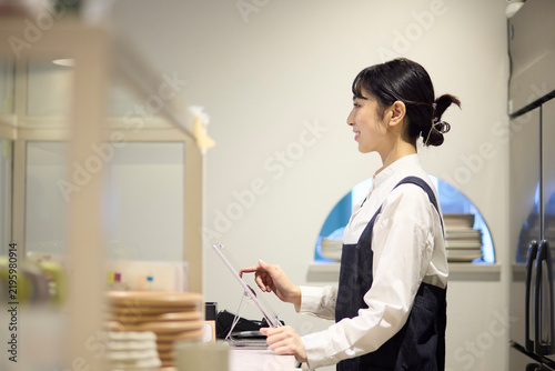 カフェでキャッシュレス決済を行う女性スタッフ