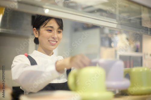カフェで食器を整理する女性スタッフ