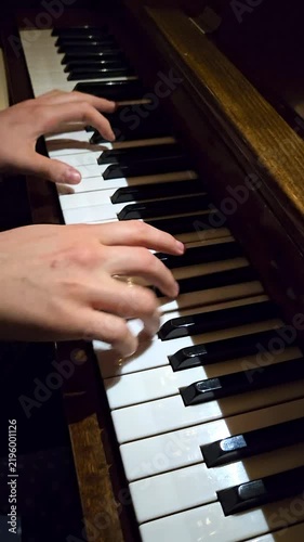 Close-up of female fingers playing on black and white piano keys in a music studio background
