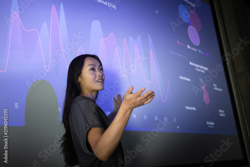 Professional Woman Presenting Data in a Conference Room