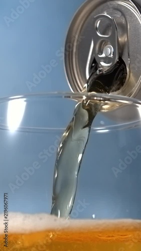 Beer pouring from aluminum can into glass in super slow motion