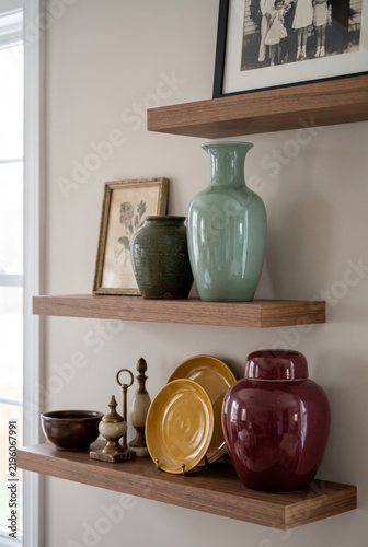 Curated, nostalgic shelves with celadon vase, ceramic plates and antique ginger jar