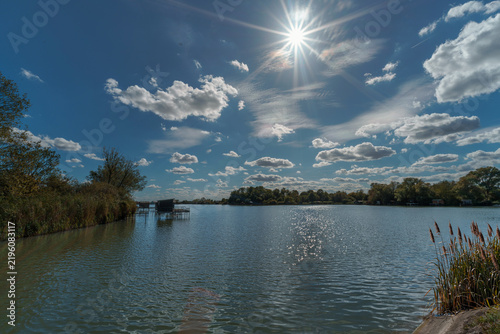 étang de pêche sous grand soleil et ciel bleu