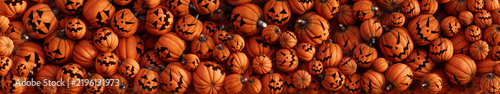 Pumpkins with spooky faces fill the screen, ultra wide panoramic background for Halloween 