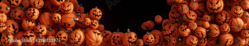 Pumpkins with spooky faces fill the screen, ultra wide panoramic background for Halloween with copy space