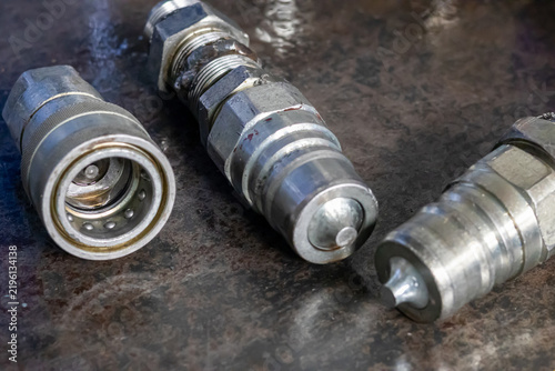 Quadro su tela Steel hydraulic quick disconnect couplers lie on dirty workshop metal workbench