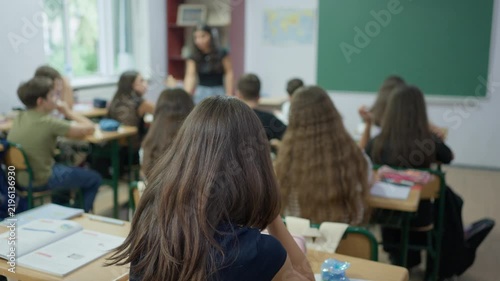 Teacher standing in front of a classroom of students during a lesson in a school environment