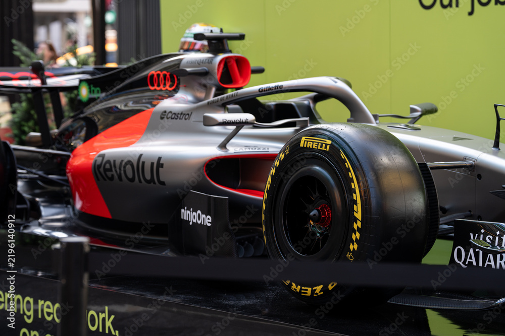 Obraz premium NEW YORK, USA – SEPTEMBER 16, 2026: a Formula 1 race car display in Times Square with sponsor branding and a close view of the front wheel and cockpit.