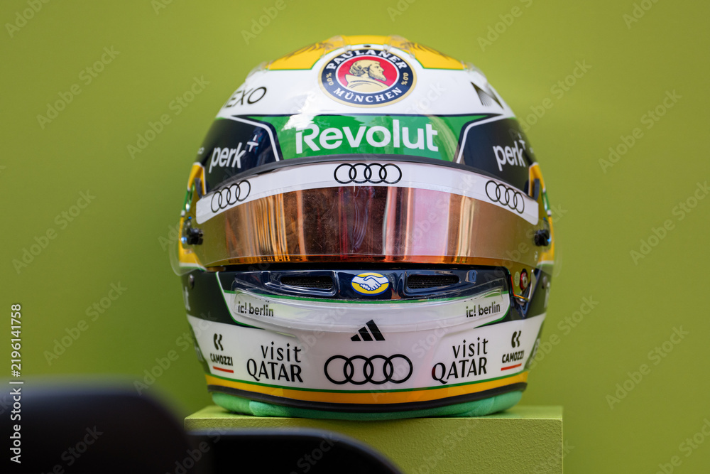 Obraz premium NEW YORK, USA – SEPTEMBER 16, 2026: a Formula One racing helmet on a pedestal with sponsor logos and a green background.