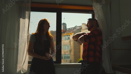 Couple having difficult conversation in kitchen window