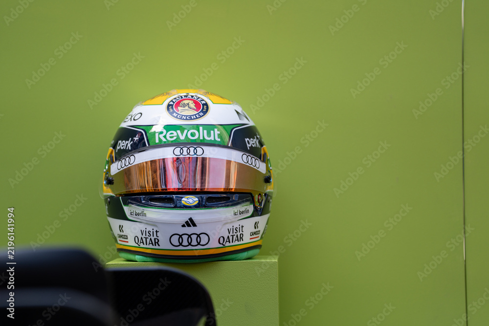 Obraz premium NEW YORK, USA – SEPTEMBER 16, 2026: a Formula One racing helmet with sponsor logos displayed against a plain green background.