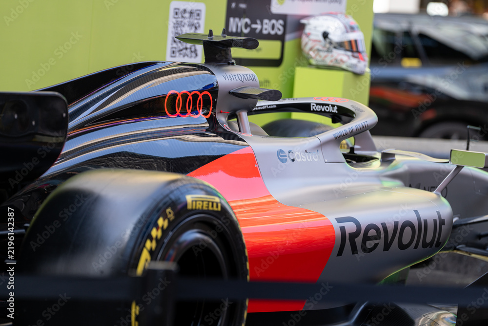Obraz premium NEW YORK, USA – SEPTEMBER 16, 2026: a Formula One race car close up at a public street display with visible sponsor logos and blurred background vehicles.