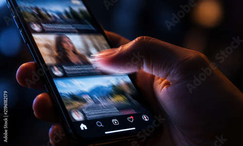 Person scrolling social media feed on smartphone at night