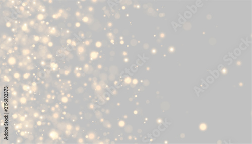 Clusters of golden bokeh lights glow softly against a black background. The lights vary in size and intensity, creating a scattered, shimmering effect.