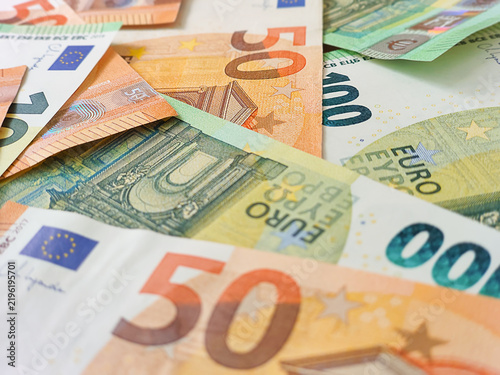 Close-up shot of scattered euro banknotes including fifty and one hundred bills, concept of wealth, European economy, cash savings, and financial success