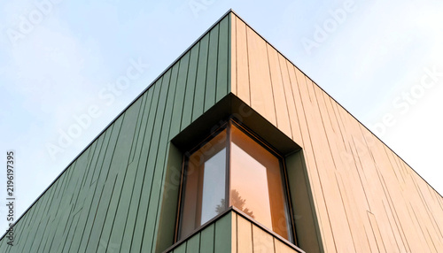 Modern sage green and sand colored building corner with window
