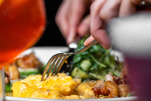 Konstfotografi Close-up of a person using a fork and knife to eat a meal with scrambled eggs, s