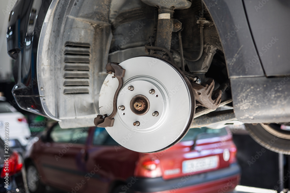 Fototapeta premium Disque de frein neuf installé sur une voiture dans un garage automobile