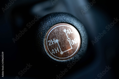 Scratched manual transfer case with low gear  shift stick close up shot.