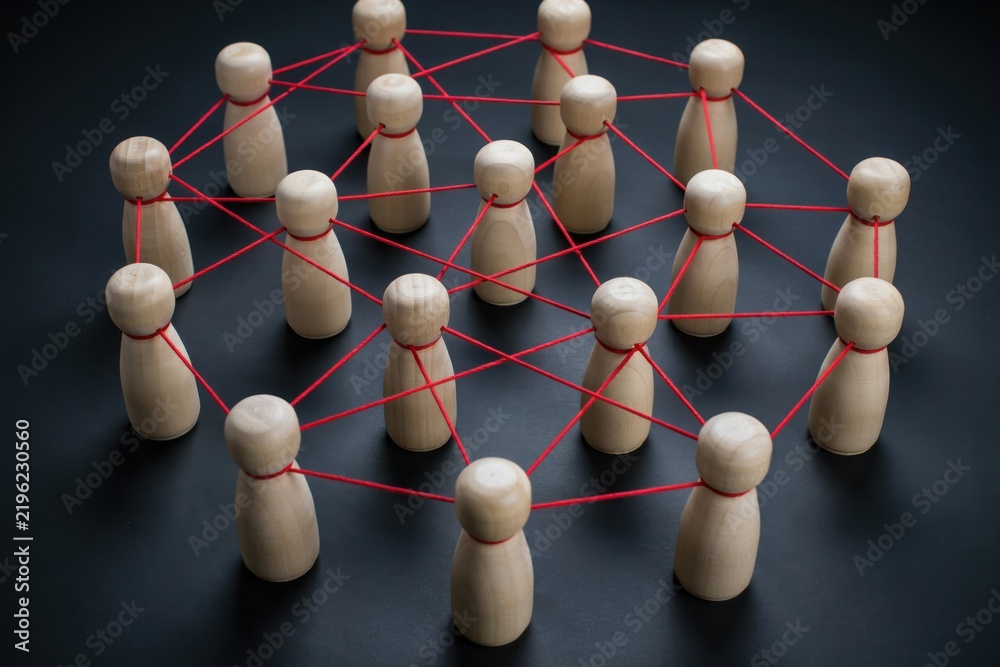 Obraz premium Wooden figures connected by red strings representing a social network or team collaboration