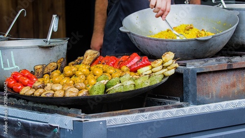 Delicious street food is being prepared at an outdoor festival cook station.
