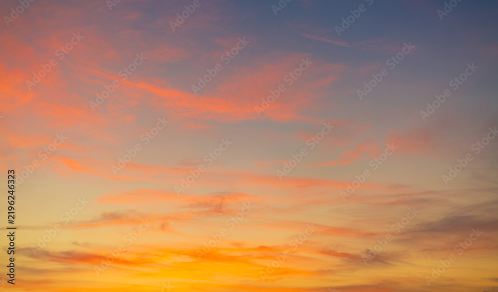 Fototapeta premium Vibrant Sunset Sky Panorama with Colorful Orange Pink and Blue Clouds,A panoramic photograph capturing a vibrant sunset sky filled with wispy cirrus clouds illuminated in golden yellow, orange, pink, 