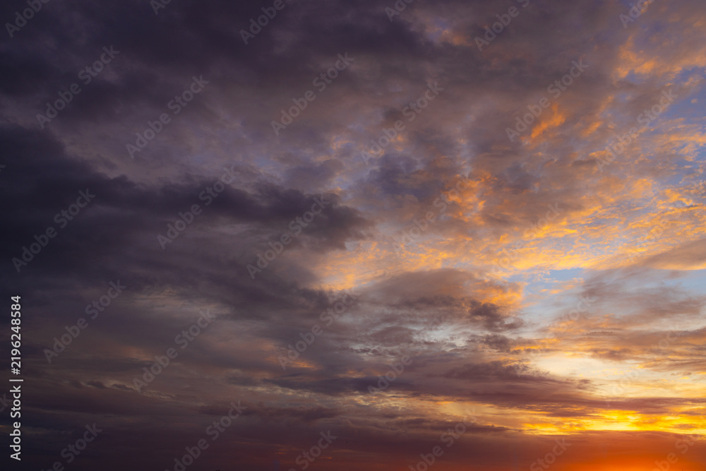 Fototapeta premium Vibrant Sunset Sky Panorama with Colorful Orange Pink and Blue Clouds,A panoramic photograph capturing a vibrant sunset sky filled with wispy cirrus clouds illuminated in golden yellow, orange, pink, 
