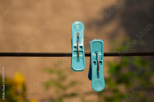 Quadro su tela Two Blue Plastic Clothes Pegs Hanging on Clothesline Close Up, Household Laundry