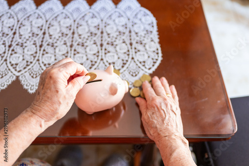 Cuadro en lienzo point of view of an elderly woman's wrinkled hands   dropping a coin into a piggy bank