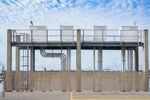Four industrial power boxes mounted on tall concrete posts at Biloxi Marina, with electrical conduit and dock lighting illuminating the waterfront.