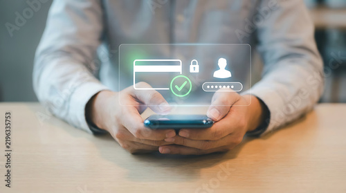 Person holds a smartphone displaying a holographic secure payment interface with a credit card icon, checkmark, locked padlock, user profile, and password entry field for banking.